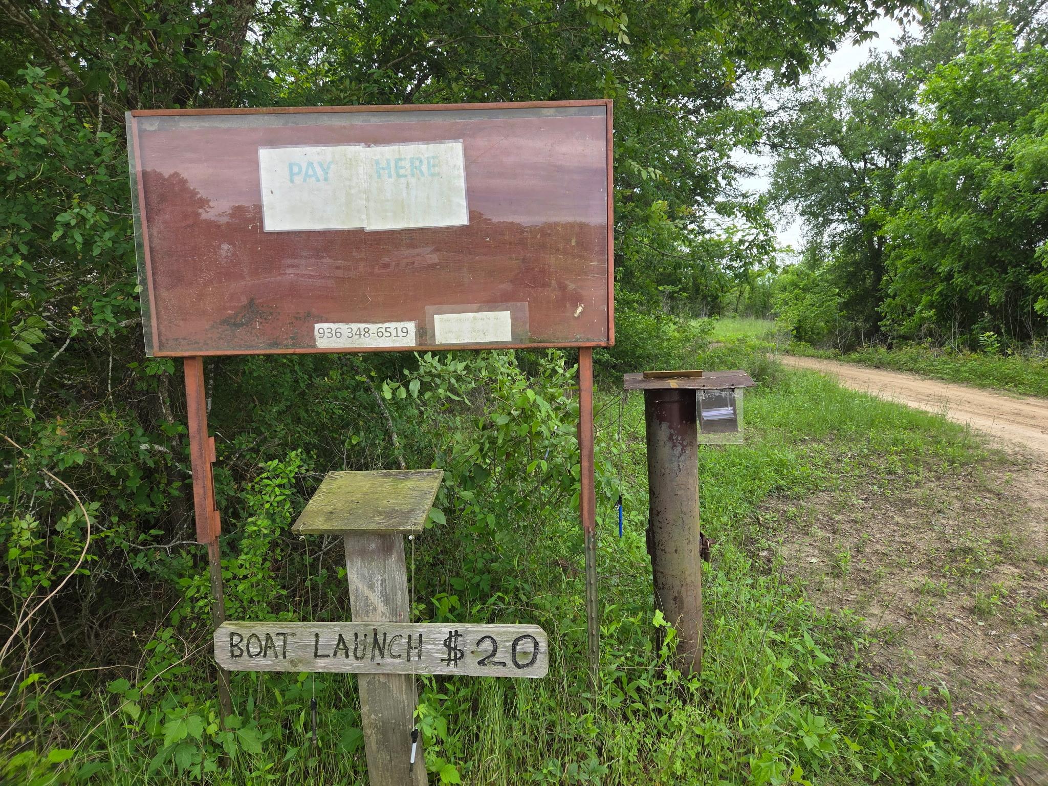 Pay Here sign and pay station at the Trinity River boat ramp entrance